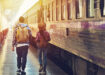 two travelers walking next to a train
