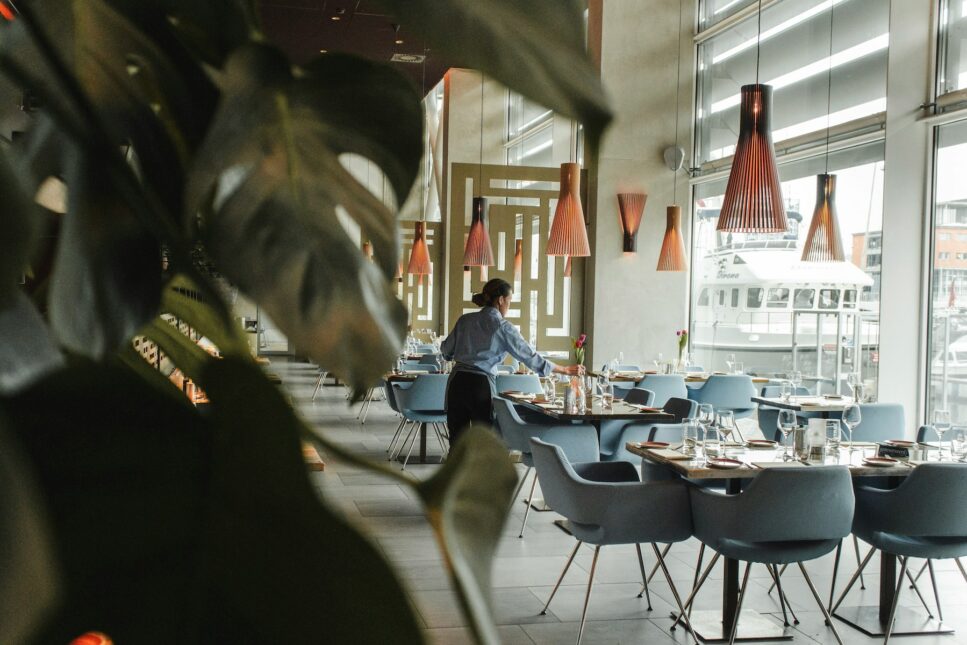 Hotel restaurant, woman setting table